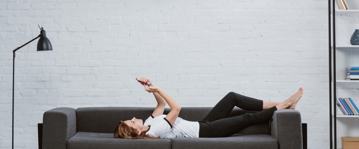 happy-young-woman-using-smartphone-on-sofa-under-a-2021-08-29-22-50-42-utc-min.jpg